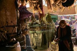 Image du Maroc Professionnelle de  Une femme traverse l'ancienne rue de la Rahba des Attarines (épiciers) au souk Semmarine de Marrakech, on trouve une multitudes d’épices ainsi que d’autres produits que l’on utilise pour la décoration des plats ou des paniers pour les grandes fêtes. Ce qui est insolite c'est que l'on y trouve aussi des objets bizarres qui sont destinés à la sorcellerie et à l’envoûtement, le 8 Décembre 2019. (Photo / Abdeljalil Bounhar) 